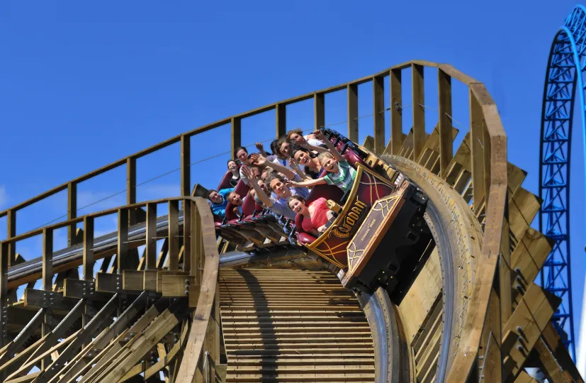 People in rollercoaster running through a steep curve