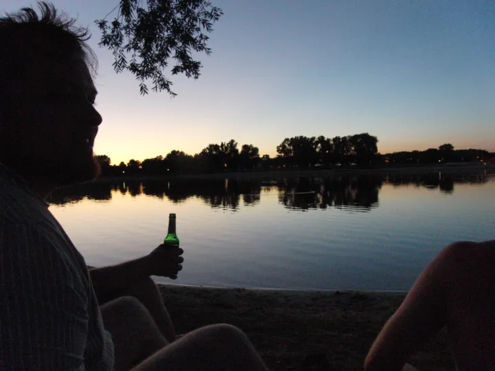 Silhouette of to persons looking at a lake at sunset, low light